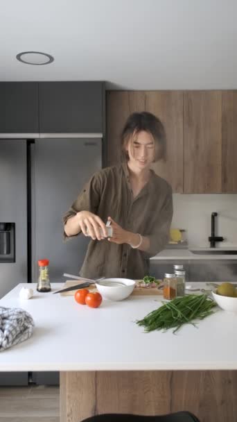 笑顔アジアの若いです男追加塩と打撃卵でキッチン — ストック動画