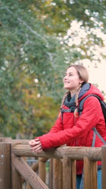 Gülümseyen genç bayan yürüyüşçü ormanda temiz hava soluyor..