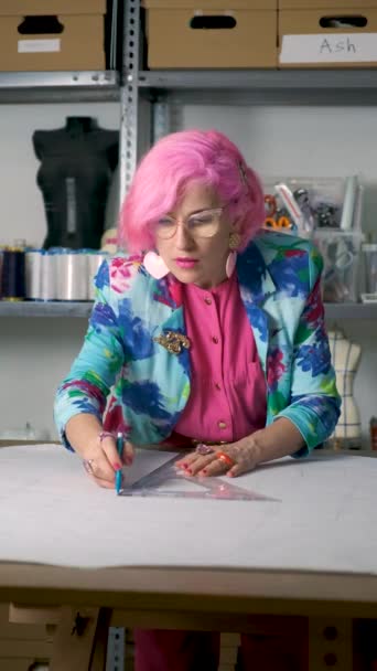 Tailor Ροζ Μαλλιά Και Πολύχρωμα Ρούχα Σχέδια Ραπτικής Ένα Εργαστήριο — Αρχείο Βίντεο