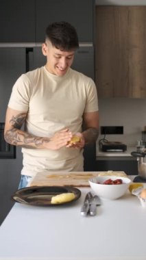 Genç Ekvadorlu adam, mutfakta peynirle doldurulmuş Llapingachos hamuru yapıyor..