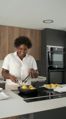 Kübalı genç bir kadın Küba usulü doldurulmuş patates hazırlamak için tavada patates püresi kızartıyor..