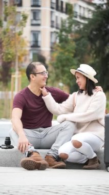 Multiracial couple of tourists hugging and kissing together. Sightseeing in Madrid, Spain.