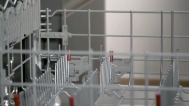 Man hand loading dirty dishes in the dishwasher. Household chores.