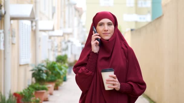 Muslim Young Woman Hijab Talking Smartphone Holding Coffee Cup Street — Stockvideo