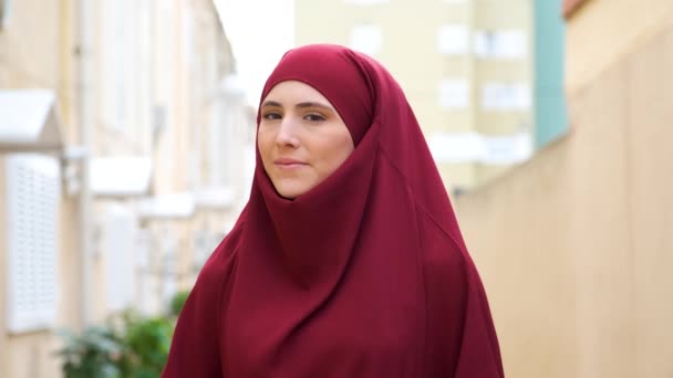 Muslim Young Woman Garnet Hijab Looking Camera Smiling Street — Stockvideo