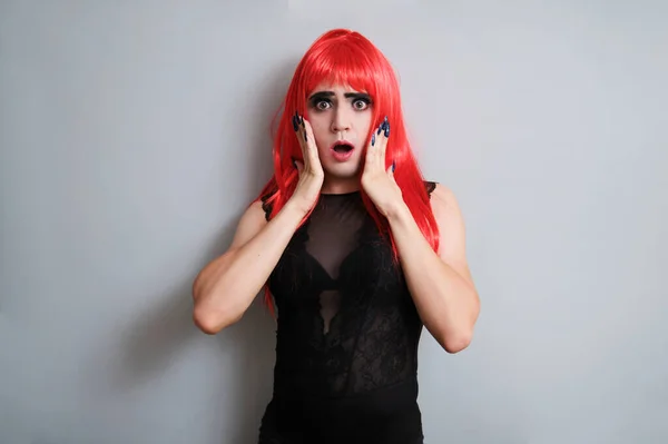 Portrait of gender fluid male dressed as female surprised and looking at camera. LGBTQ queer.