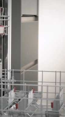 Man hand loading dirty dishes in the dishwasher. Household chores.