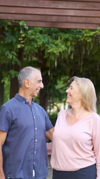 부부는 서로를쳐다보며 카메라를 거리의 공원에서 미소짓는다 — 비디오