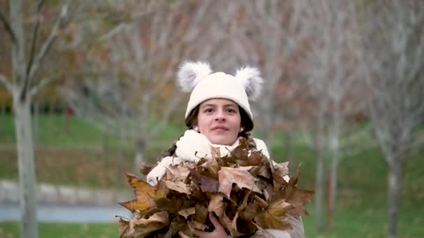 十多岁的女孩在秋天的时候把秋天的叶子抛向空中 — 图库视频影像