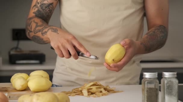 Young Unrecognizable Tattooed Latin Man Peeling Potatoes Kitchen Prepare Recipe — ストック動画