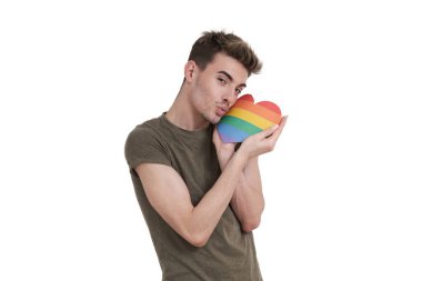 Young caucasian man throwing a kiss with lgbt flag heart, isolated on white background. clipart