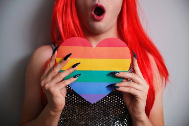 Gri arka planda gökkuşağı bayrağı taşıyan tanınmamış bir transseksüel sürpriz yaptı. LGBTQ eşcinseli.