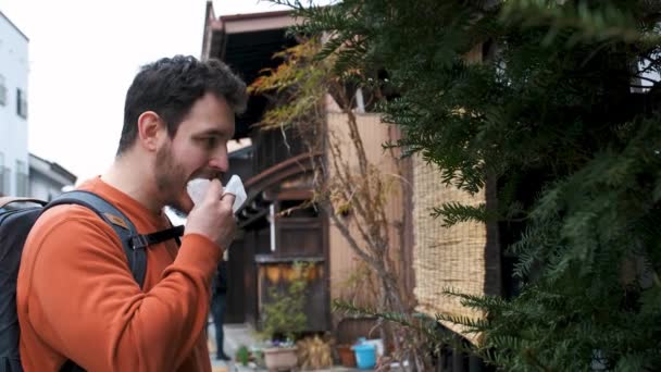 日本Gifu市Hida市Takayama镇的一条日本街道上 一位欧洲游客正在吃着一位尼库曼人 — 图库视频影像