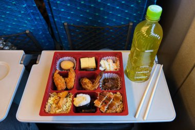Japon Eki Bento, beslenme çantası ve Japonya 'da bir Shinkansen treninde bir şişe yeşil çay..