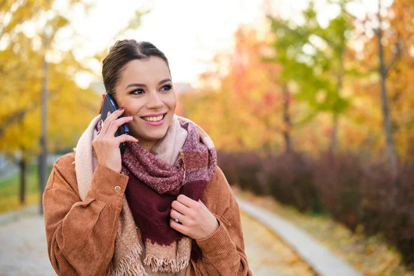 stock image Caucasian young woman on a phone call smiling in autumn.