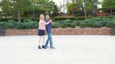 Caddedeki parkta tango yapan olgun mutlu çift..