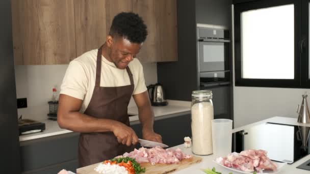 Молодой Черный Человек Раздевает Курицу Приготовить Рецепт Кухне — стоковое видео