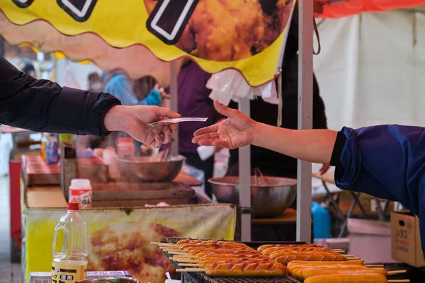 stock image Kyoto, Japan. April 25, 2023: Person buying a Fried Sausage Stick at a kiosk, street food in Kyoto.