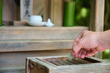 El, Japon Tapınağı, Kyoto, Japonya 'da ahşap bağış kutusu veya Saisen Kutusu şeklinde bir bağış yapıyor..