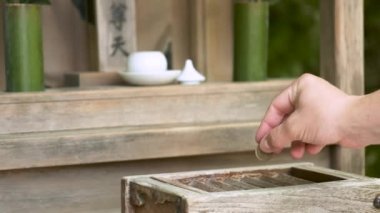 El, Japon Tapınağı, Kyoto, Japonya 'da ahşap bağış kutusu veya Saisen Kutusu şeklinde bir bağış yapıyor..