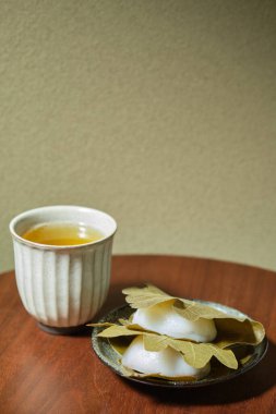 Japon Kashiwa mochi ve yeşil çay. Meşe yaprağıyla sarılmış kırmızı fasulye ezmeli Japon mochi 'si. Japon tatlıları..