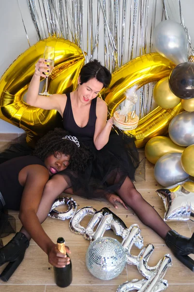 两个多种族醉酒妇女在一个40岁生日宴会上喝着香槟酒和蛋糕 — 图库照片