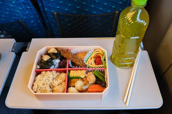 stock image Japanese Eki Bento, lunch box, and a bottle of green tea on a Shinkansen Train in Japan.