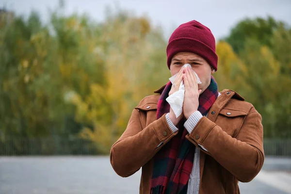 冬にはラテン系の青年が鼻を組織に吹き込む 寒い天気 — ストック写真