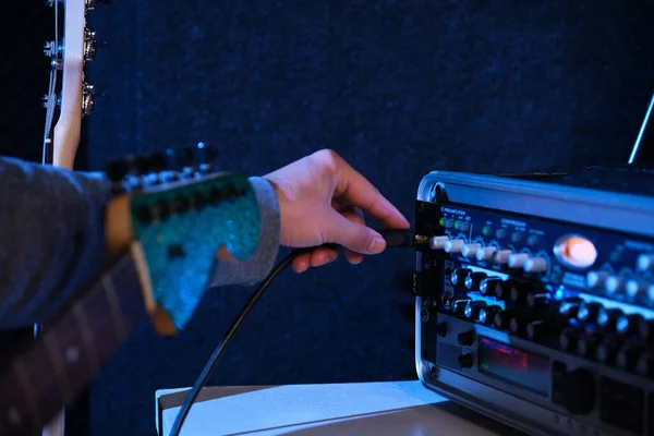 エレキギターをミキシングコンソールに接続するミュージシャンの手を閉じてください 音楽制作 — ストック写真