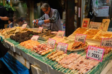 26 Mayıs 2023 'te Osaka, Japonya' da Osaka pazarında kaynak makineleriyle taze deniz ürünleri satan bir satıcı..