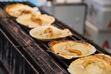 Japonya 'nın Osaka şehrindeki pazarda satılan ızgara midyelerini kapatın. Sokak yemekleri ve seyahat kavramları.