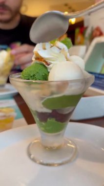 Japon mutfağında sembolik bir tatlı olan Matcha, Anko ve Mochi Parfe yiyen Latin turistler Japonya 'da bir restoranda.