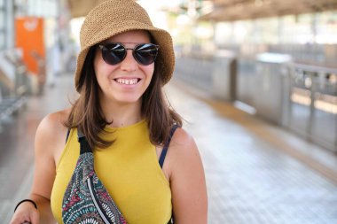 Japonya 'daki Ito tren istasyonunda bavullu mutlu bir bayan turist..