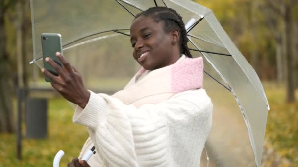 African Woman Taking Selfie Smartphone Transparent Umbrella Smiling Autumn — Stock Video