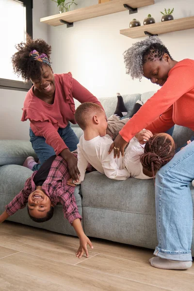 Happy african family playing on sofa, enjoy and having fun together. Horizontal extended family.