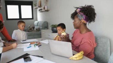 African family having a snack while painting or doing the homework. Horizontal extended family spending time together.
