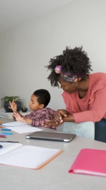 Afrikalı anne, oğluna ev ödevinde yardım ediyor..