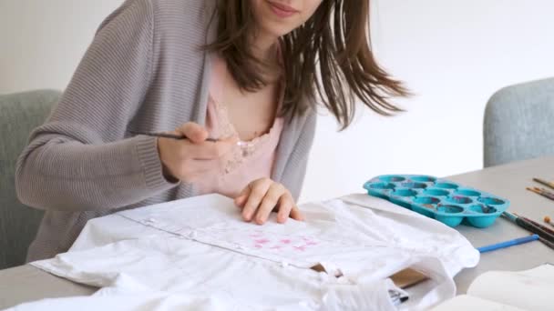 Caucasian Woman Hand Painting Design Using Acrylic Paints White Shirt — Vídeo de stock