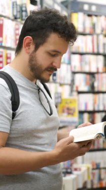 Tokyo 'da bir çizgi roman dükkanında Japonca yazılmış bir çizgi roman okuyan Latin turist..