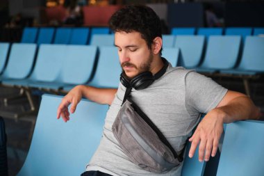 Narita havaalanında uyumaya çalışan bir adam. Uçağı rötar yaptığı için üzgün..