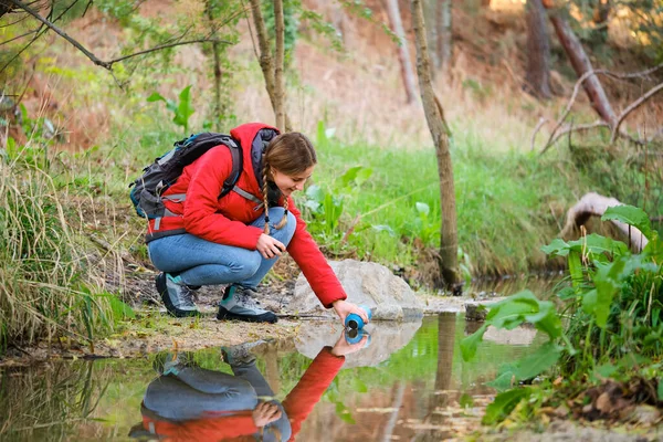 Молодая Женщина Туристка Наполняет Флягу Сырой Водой Реке — стоковое фото