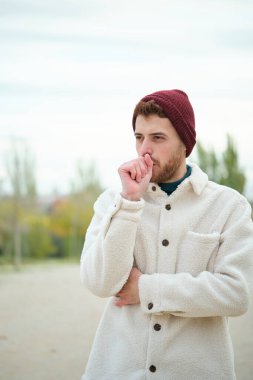 Latin genç adam kış boyunca öksürüyor. Soğuk hava. Grip..