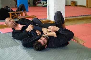 Akademide Brezilya Jiu-Jitsu güreşi yapan iki adam. BJJ eğitimi.