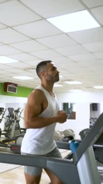 Spor salonunda koşu bandında koşan güçlü bir İspanyol..