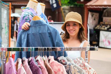 Tokyo, Japonya 'da bir Japon sokak dükkanında kimono seçen bir turist kadın..