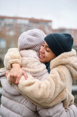 Dominikli lezbiyen çift, bir kış günü sokakta sevgi ve sevgiyle sarılıyorlar..