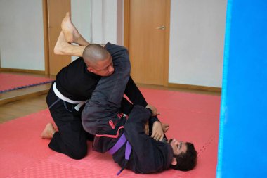 İki adam okulda Brezilya Jiu-Jitsu antrenmanı yapıyor. BJJ eğitimi.