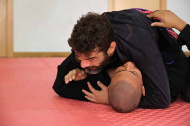 İki adam okulda Brezilya Jiu-Jitsu antrenmanı yapıyor. BJJ eğitimi.