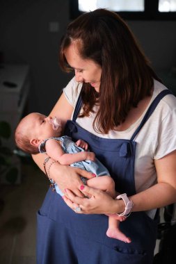 Kafkasyalı mutlu anne bir aylık kızını kucağında tutuyor. Bebek bakımı.