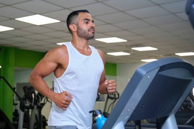 Spor salonunda koşu bandında koşan güçlü bir İspanyol..